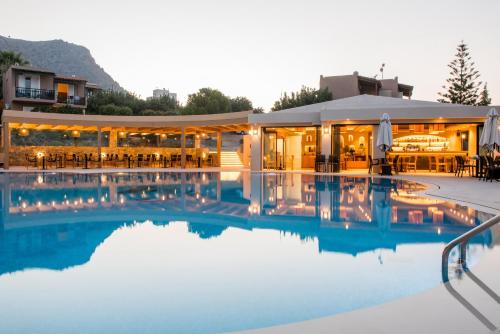 a swimming pool in front of a building at Marni Village in Hersonissos
