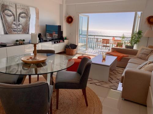 een woonkamer met een glazen tafel en een bank bij Beachfront apartment in Fuengirola in Fuengirola