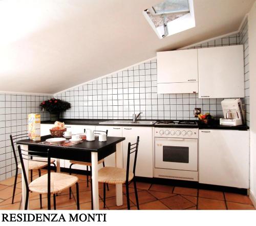 y cocina con mesa, sillas y fogones. en Residenza Monti, en Roma