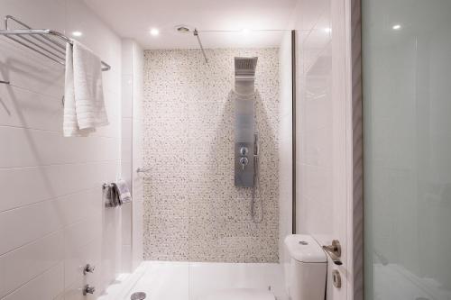 a white bathroom with a shower and a toilet at Spiti Prifti Apartments in Gouvia