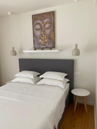 a bedroom with a bed with a mask above it at Baltimore.House in Baška Voda