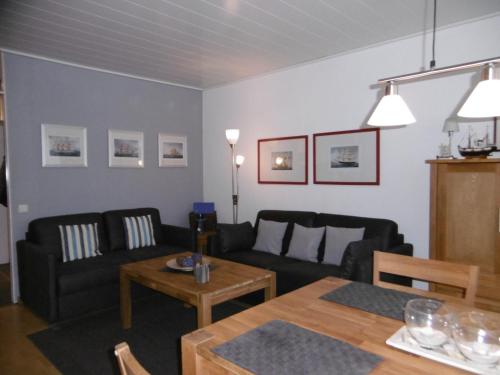 Burgtiefe auf Fehmarn にあるFerienwohnung-am-Suedstrand-2のリビングルーム(ソファ、テーブル付)