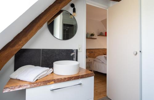 a bathroom with a sink and a mirror on a counter at Le Manoir des Falaises - Chambres d'hôtes in Saint-Jouin-Bruneval