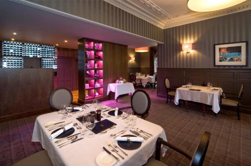 a dining room with two tables with white tablecloths at Isle of Eriska Hotel Spa & Island in Benderloch