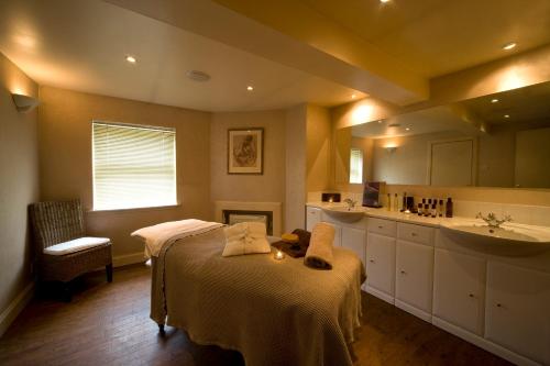 a bathroom with a bed and a sink and a tub at Isle of Eriska Hotel Spa & Island in Benderloch