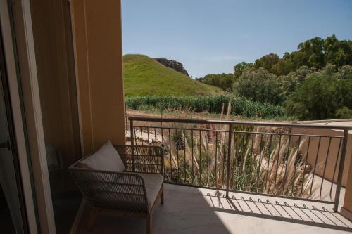 a balcony with a chair and a view of a hill at Luna Minoica Suites and Apartments in Montallegro