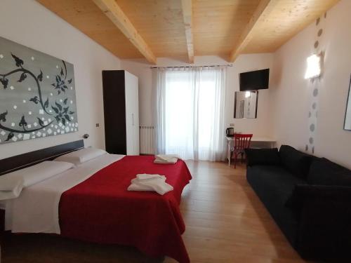 a bedroom with a red bed and a couch at the Mainstreet in Agerola