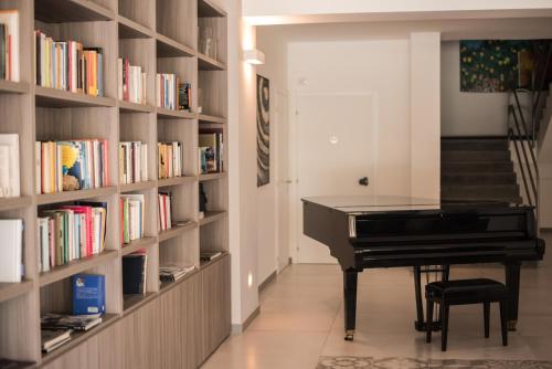 a library with a piano in a room with books at Luna Minoica Suites and Apartments in Montallegro