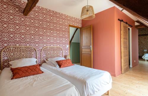 a bedroom with two beds and a red wall at Le Manoir des Falaises - Chambres d'hôtes in Saint-Jouin-Bruneval