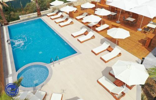 an overhead view of a swimming pool with lounge chairs and umbrellas at Blue Water Hotel Ksamil in Ksamil