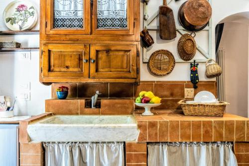 eine Küche mit Holzschränken und einem Waschbecken in der Unterkunft Casa Tòrta in Monticchiello