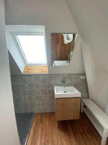 ein Badezimmer mit Waschbecken und Oberlicht in der Unterkunft Studio Vue Mer in Boulogne-sur-Mer