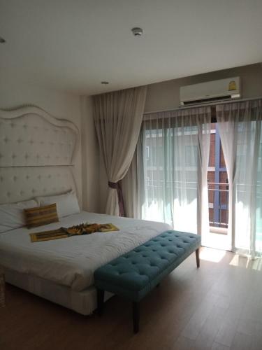 a bedroom with a large bed with a blue bench at Zotel in Chiang Mai
