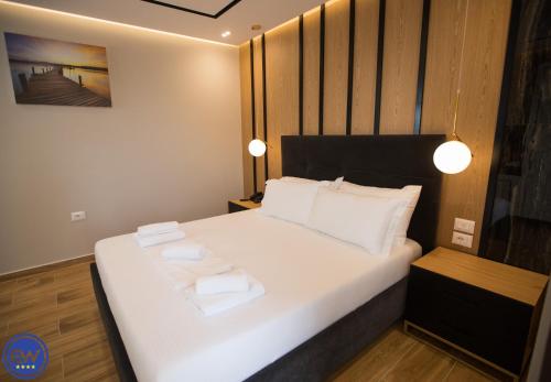 a bedroom with a white bed with two towels on it at Blue Water Hotel Ksamil in Ksamil