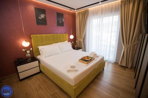 a bedroom with a bed with a tray of food on it at Blue Water Hotel Ksamil in Ksamil