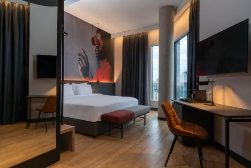 a hotel room with a bed and a desk at Radisson RED Hotel Johannesburg Rosebank in Johannesburg