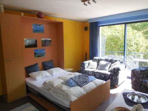 sypialnia z łóżkiem, krzesłem i oknem w obiekcie DURBUY RESIDENCE -A201- w mieście Durbuy