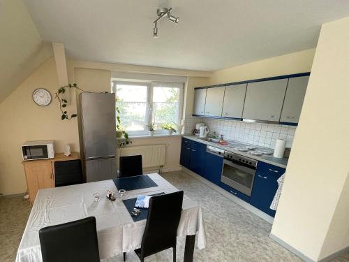 a kitchen with blue cabinets and a table with chairs at Freundliche Zweiraumwohnung in ruhiger Lage in Cottbus