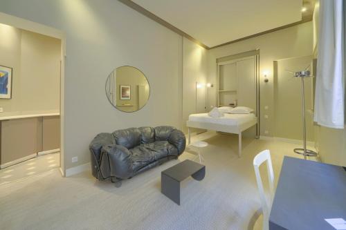 sala de estar con sofá de cuero y cama en Le Nuage - Studio design à Triangle d'Or, en Burdeos