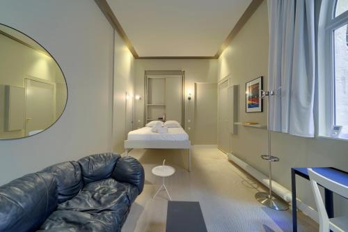 sala de estar con sofá de cuero y cama en Le Nuage - Studio design à Triangle d'Or, en Burdeos