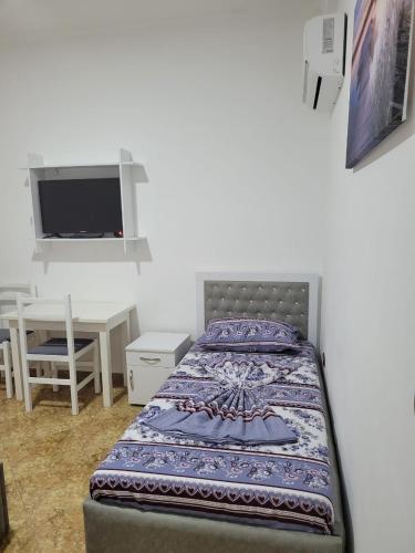a bedroom with a bed and a table and a tv at Hotel Reci in Peshkopi