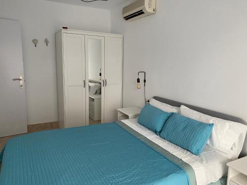 a bedroom with a bed with blue and white pillows at Apartamento Aguamarina in Almerimar