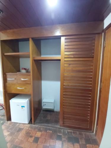 a closet with a wooden door and a refrigerator at Amoaras Resort in Maria Farinha