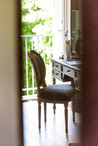 a chair sitting in front of a desk with a mirror at La Closerie Saint-Vincent, chambres d'hôtes Amboise in Pocé-sur-Cisse