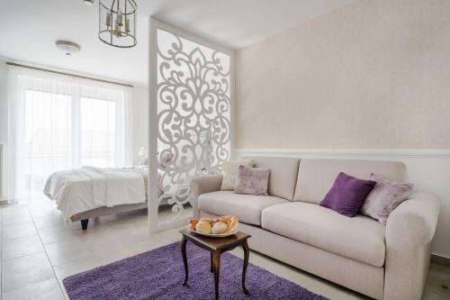 uma sala de estar com um sofá e uma cama em Katica Szállás em Balatonkenese