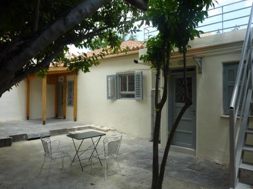 a patio with chairs and a table in front of a house at A Painter's House in Plaka in Athens