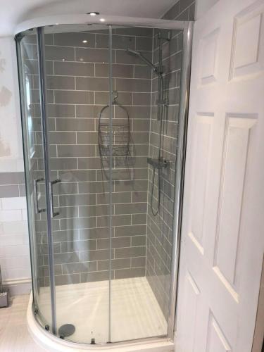 a shower with a glass door in a bathroom at Hideaway at Botany Bay in Broadstairs
