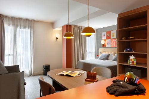 a hotel room with a bedroom with a bed and a table at RockyPop Flaine Hotel & Spa in Flaine