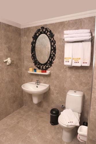 a bathroom with a sink and a toilet and a mirror at Buldum Otel in Ankara