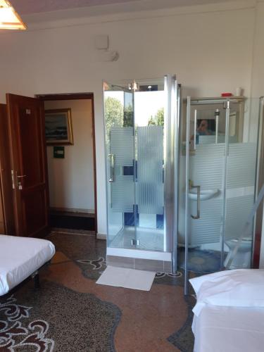 a bathroom with a shower and a glass door at Hotel Guesthouse MASSENA in Genova