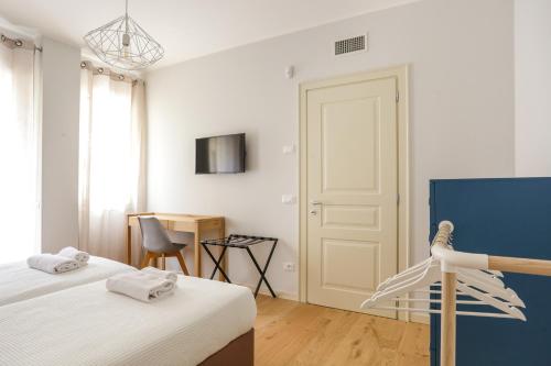 a bedroom with two beds and a door and a chair at Treviso City Town 2 in Treviso
