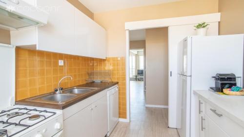 a kitchen with a sink and a stove at Epsom - Appartement en front de mer Arcachon in Arcachon