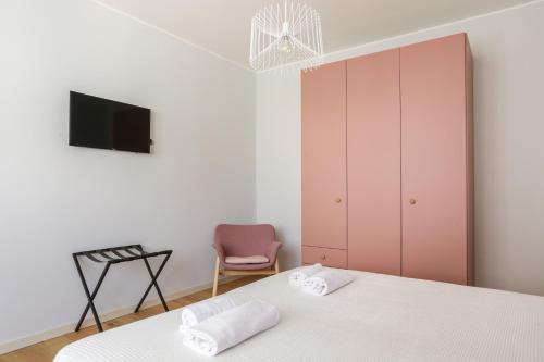 a bedroom with a bed and a tv and a chair at Treviso City Town 2 in Treviso
