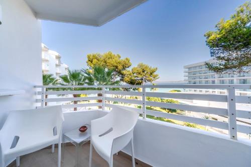 a balcony with white furniture and a view of the ocean at Playa Esperanza Resort Affiliated by Meliá in Playa de Muro