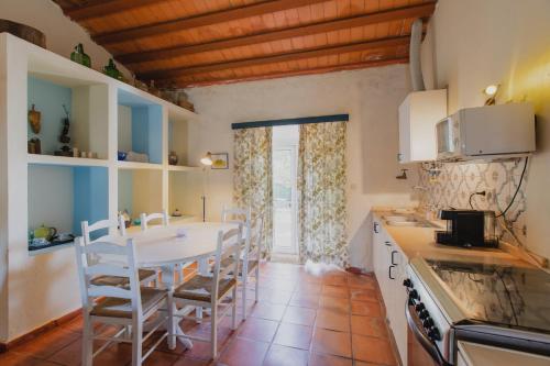 a kitchen with a table and chairs in a room at Monte Da Serralheira Agro Turismo in Évora