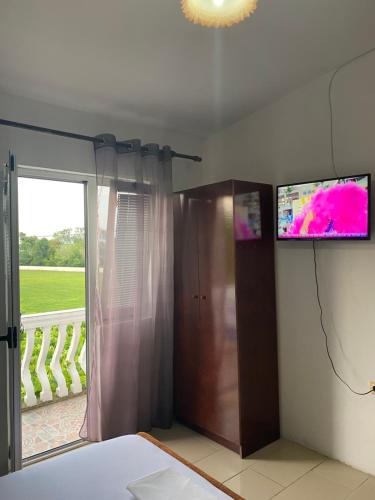 um quarto com uma cama e uma televisão na parede em Kastrati Apartments em Ulcinj