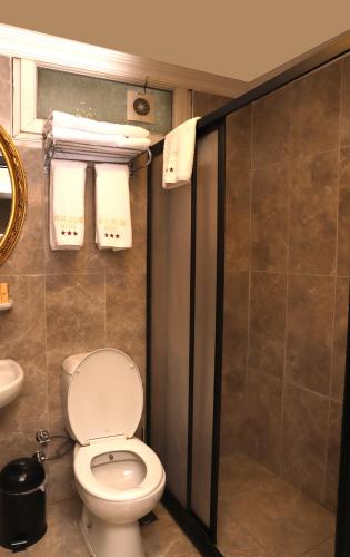 a bathroom with a toilet and a sink and towels at Buldum Otel in Ankara