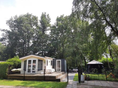 a tiny house with a porch and a gazebo at VakantieNoord, chalet 6p with veranda, located in Friesland, 5 stars camping on the lake in Suameer