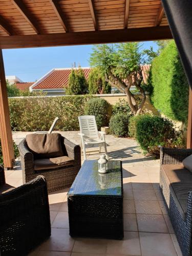 a patio with chairs and a table on a patio at Melanta Villa in Pissouri