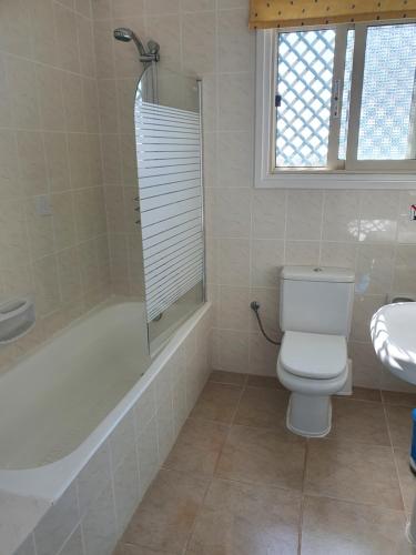a bathroom with a toilet and a tub and a sink at Melanta Villa in Pissouri