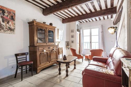 a living room with a couch and a table at Maison de village au coeur de l'Isle-sur-la-Sorgue in L'Isle-sur-la-Sorgue