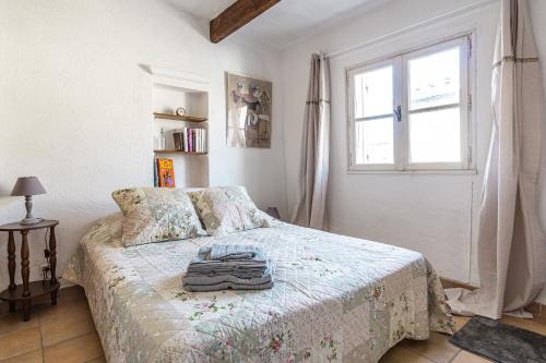 a bedroom with a bed and a window at Maison de village au coeur de l'Isle-sur-la-Sorgue in L'Isle-sur-la-Sorgue