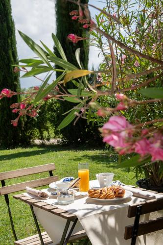 a table with a plate of food and orange juice at Relais Villa Isabel in Pietrasanta