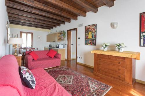 salon z czerwoną kanapą i stołem w obiekcie Alla Barchessa di Villa Querini w mieście Preganziol