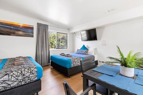 Habitación de hotel con cama y comedor en Surf Beach Motel Coffs, en Coffs Harbour