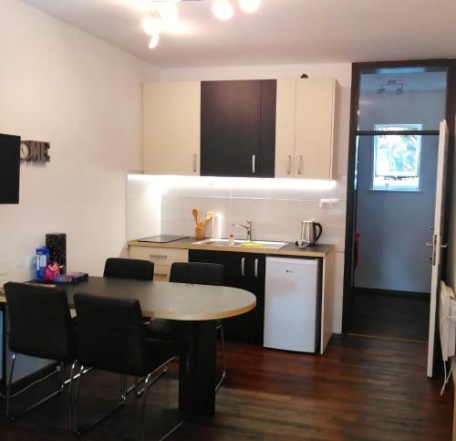 a kitchen with a table and chairs and a sink at Rogla Apartma Gaber54 in Zreče